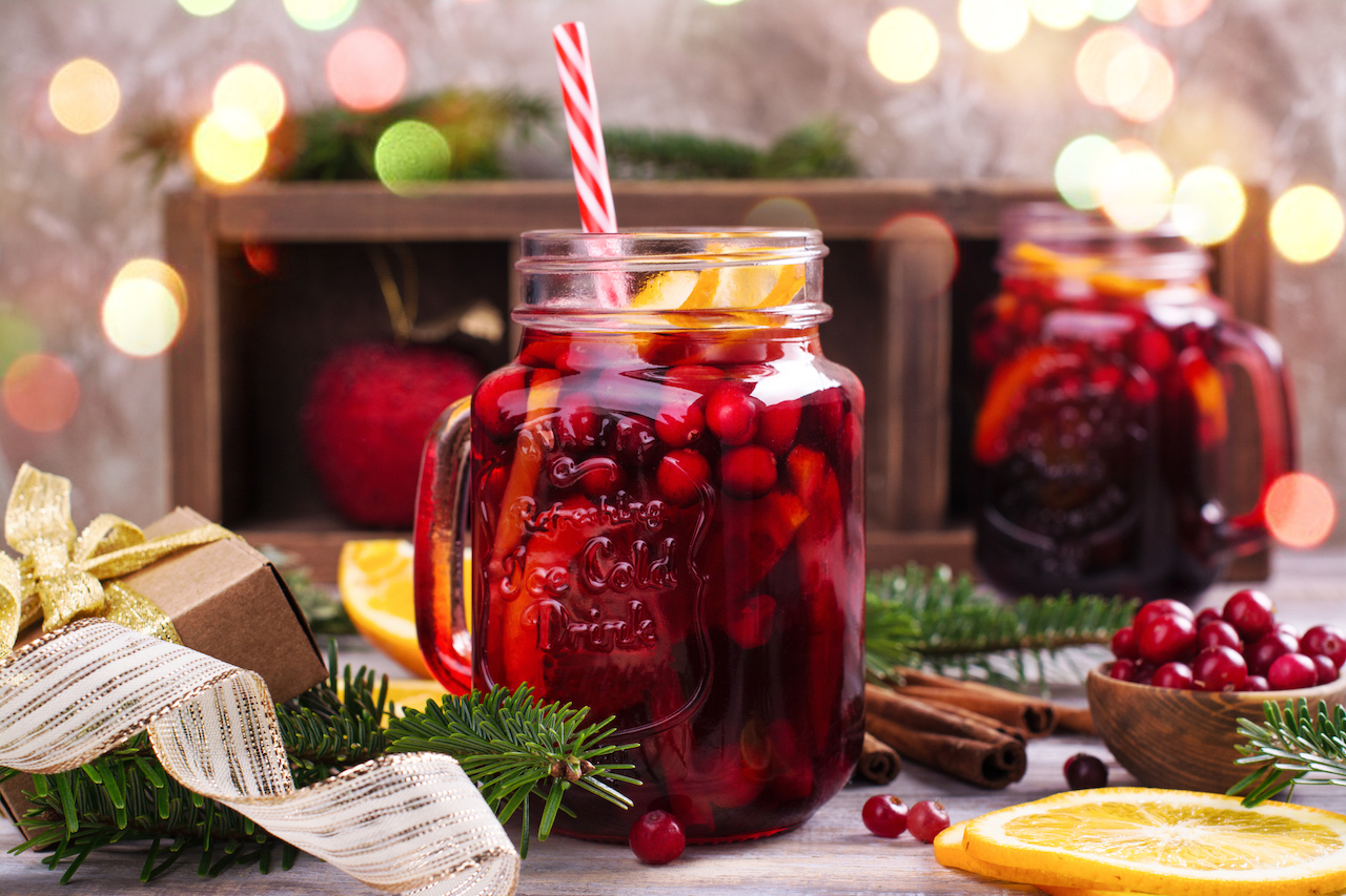 Cranberry and orange winter sangria near fireplace